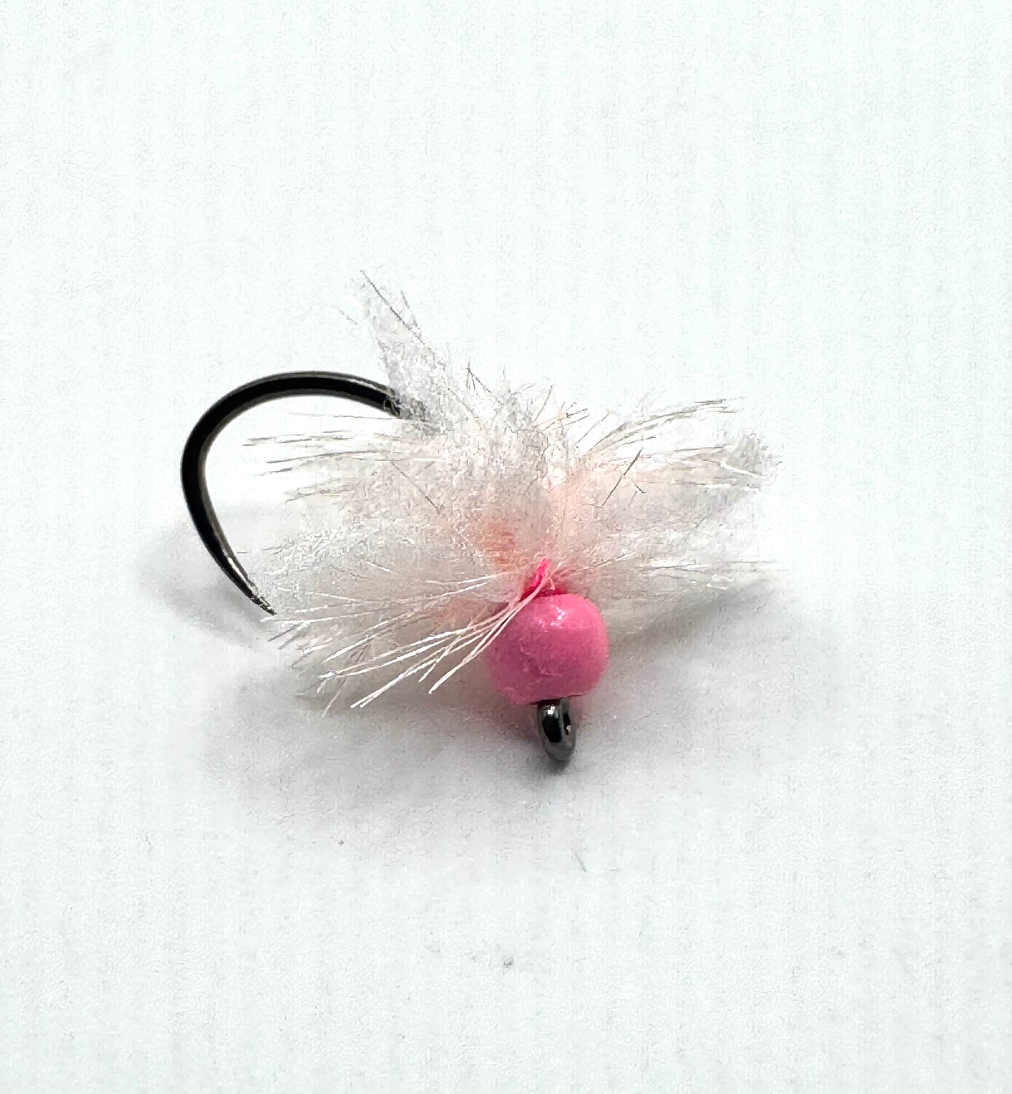 Pink bead fly lure on black hook with white feathery hackle fibers